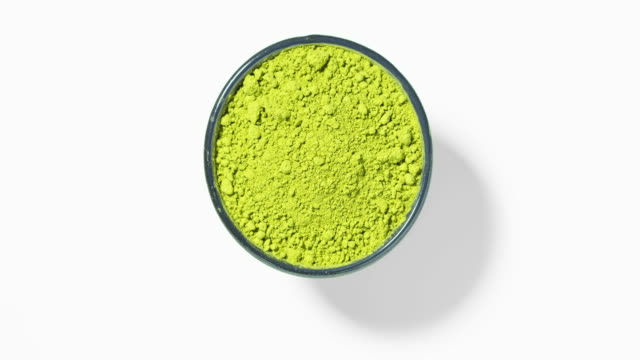 Matcha green tea in round bowl on white background, seamless loop