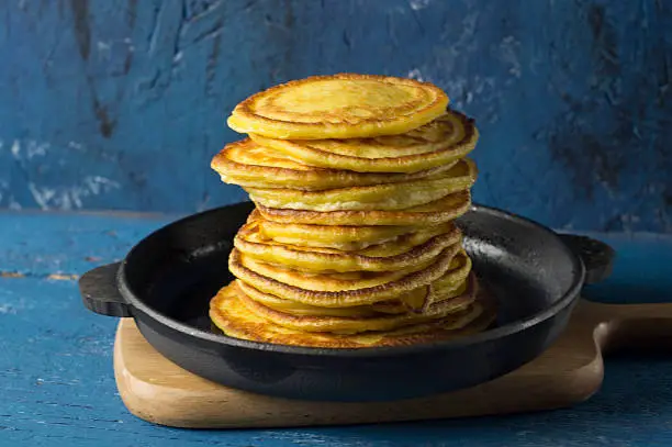 Frying pan of freshly baked pancakes, Ingredients and kitchenware for pancakes making.