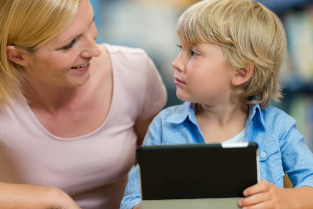 istock Preschool Boy With His Mother In Public Library 1087183544
