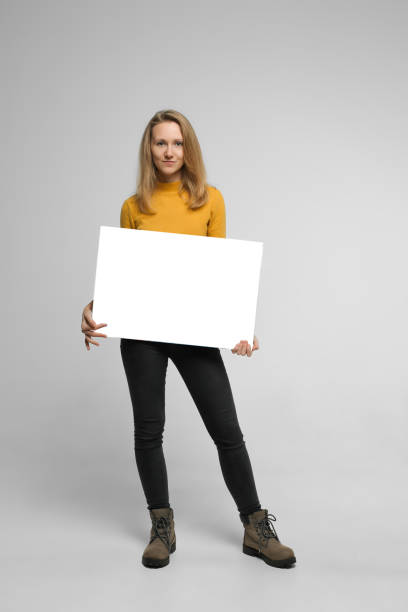 istock Smiling young woman with poster 1087186310