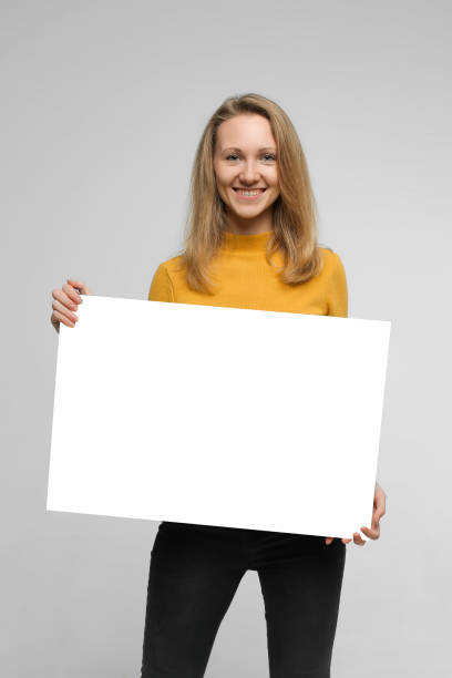 istock Smiling young woman with poster 1087186350