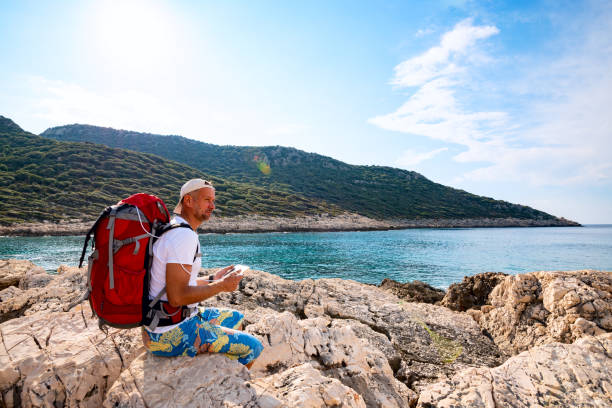 istock Happy traveler with a portable solar battery attached to his backpack 1087204468