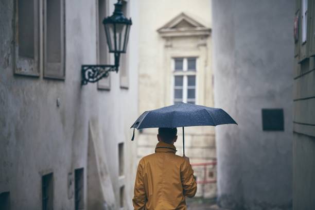 istock Lonely man with umbrella in rain 1087205476