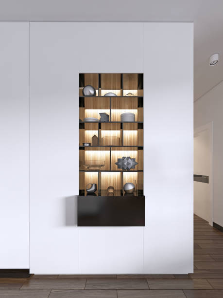 istock Built-in black shelves with decor against a white wall with lighting. 1087210240