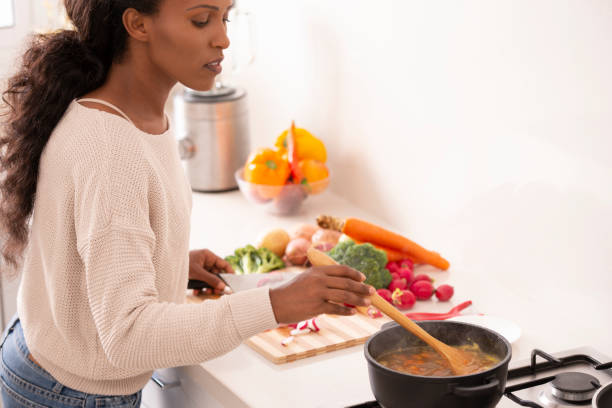 istock Woman stirring vegetable soup. 1087212366