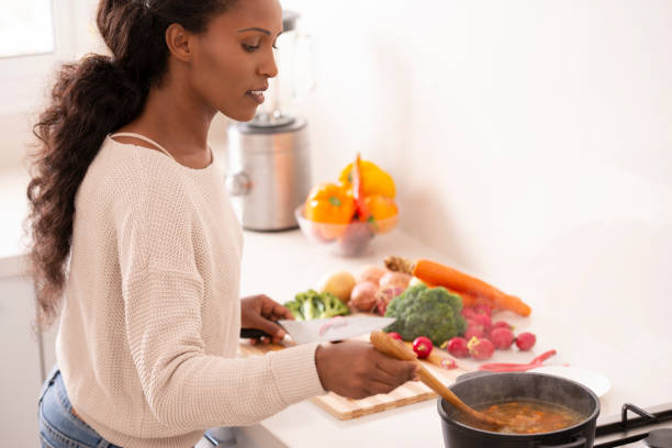 istock Woman stirring vegetable soup. 1087215408