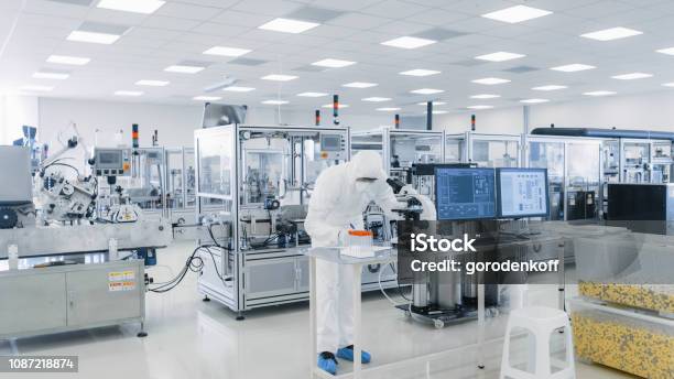 Shot Of Sterile Pharmaceutical Manufacturing Laboratory Where Scientists In Protective Coveralls Do Research Quality Control And Work On The Discovery Of New Medicine Stock Photo - Download Image Now