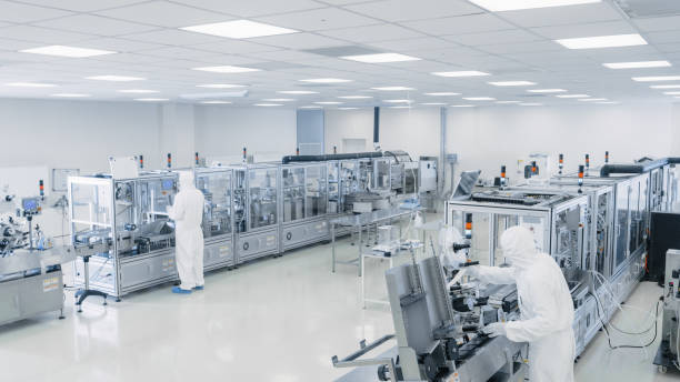 istock Sterile High Precision Manufacturing Laboratory where Scientists in Protective Coverall's Turn on Machninery, Use Computers and Microscopes, doing Pharmaceutics, Biotechnology and Semiconductor Research. 1087218932