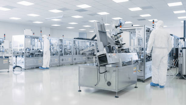 istock Sterile High Precision Manufacturing Laboratory where Scientists in Protective Coverall's Turn on Machninery, Use Computers and Microscopes, doing Pharmaceutics, Biotechnology and Semiconductor Research. 1087218992