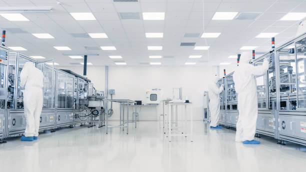 istock Team of Research Scientists in Sterile Suits Working with Computers, Microscopes and Modern Industrial Machinery in the Laboratory. Product Manufacturing Process: Pharmaceutics, Semiconductors, Biotechnology. 1087219024