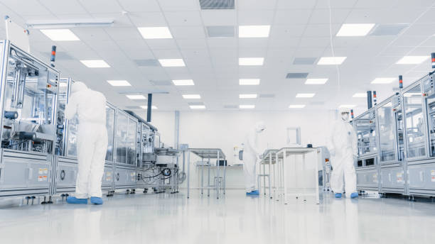 istock Team of Research Scientists in Sterile Suits Working with Computers, Microscopes and Modern Industrial Machinery in the Laboratory. Product Manufacturing Process: Pharmaceutics, Semiconductors, Biotechnology. 1087219036