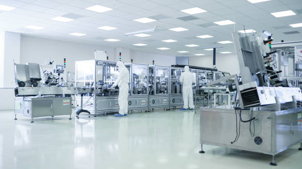 istock Sterile High Precision Manufacturing Laboratory where Scientists in Protective Coverall's Turn on Machninery, Use Computers and Microscopes, doing Pharmaceutics, Biotechnology and Semiconductor Research. 1087219698