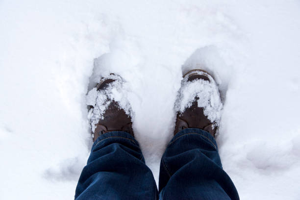 istock Feet in boots in the snow, top view 1087219892