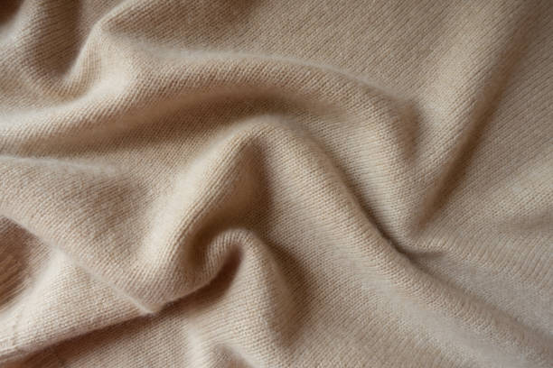 istock Pale beige knitted fabric in soft folds 1087223816