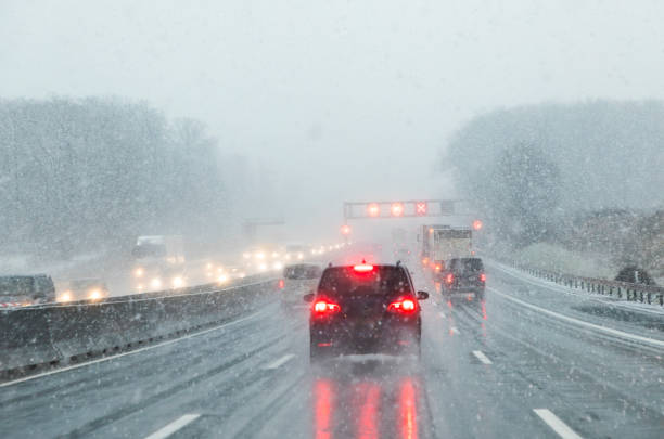 istock highway with cars in winter with snow fall 1087228102