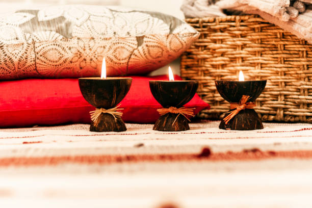 istock Burning spa aroma candles in coconut shell, pillows and plaid, cozy home interior background 1087229354