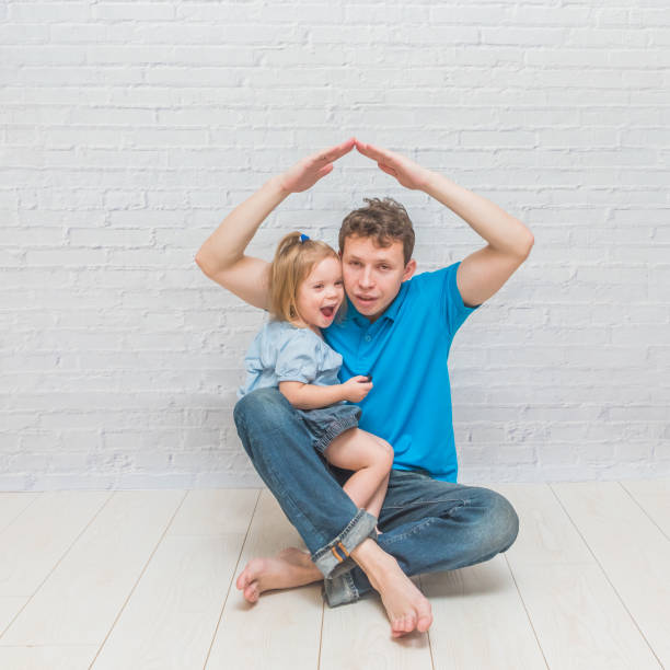 istock girl climbs, playing with dad on a white brick wall 1087234746