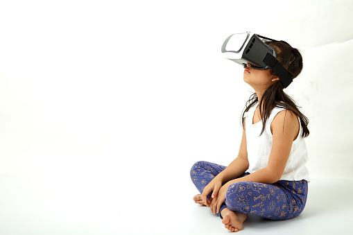 Cute girl having fun with virtual reality headset. Innovation technology and education concept. white background