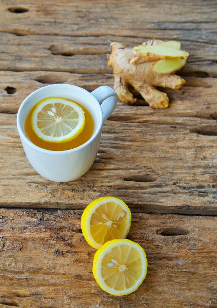 istock Cup of ginger tea with lemon on wooden table 1087236610