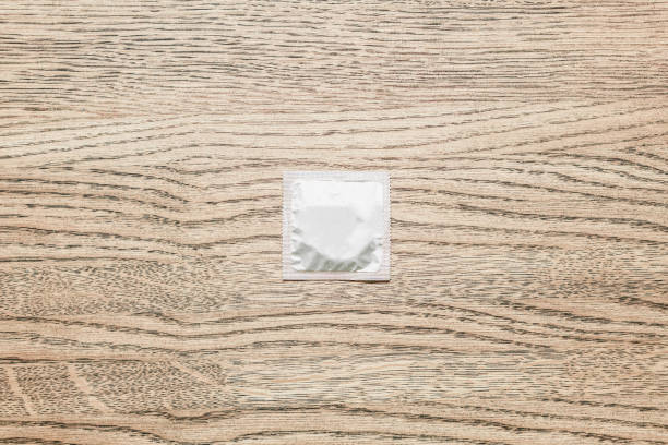 istock Condom on wood background. 1087237112