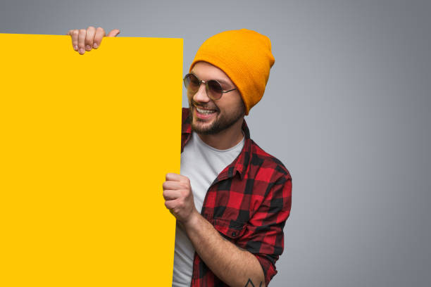 istock Cheerful man holding yellow poster 1087238496
