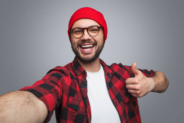 istock Cheerful man taking selfie and gesturing thumb-up 1087238514