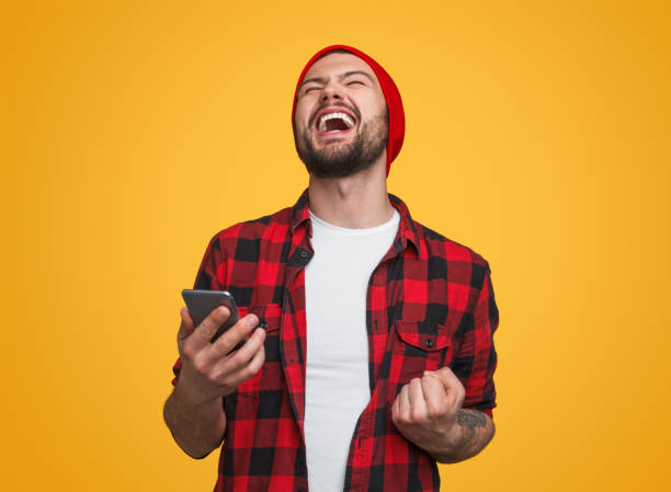 Happy male with smartphone celebrating success