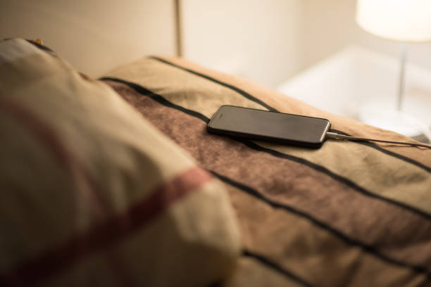lo smartphone si ricarica sul letto - hotel wireless technology bedroom hotel room foto e immagini stock