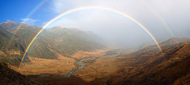 Rainbow in Autumn mountain valley stock photo