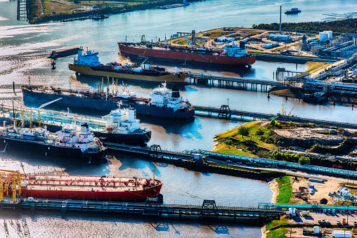 A group of international oil tankers docked at an oil refinery loading fuel for transport to various nations around the world.  This aerial shot is a refinery located just outside of Houston, Texas.