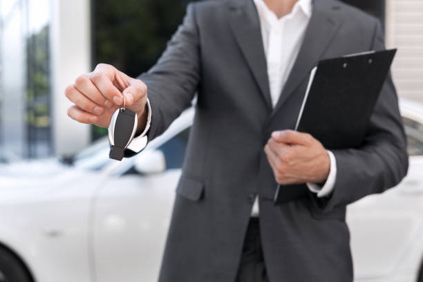 istock Car sale. Consultant with documents giving car key over auto 1087249048
