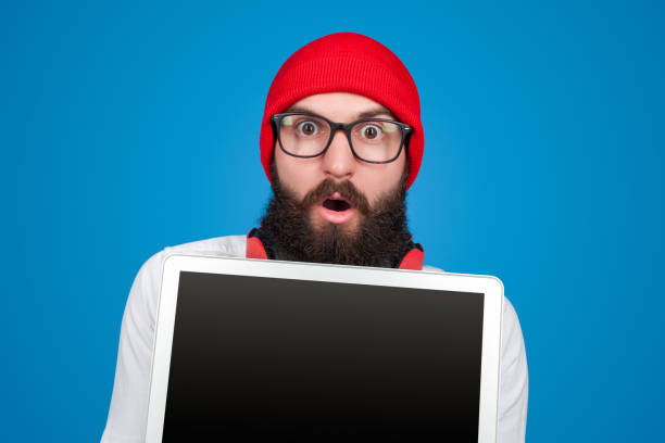 istock Shocked hipster guy with laptop 1087249156