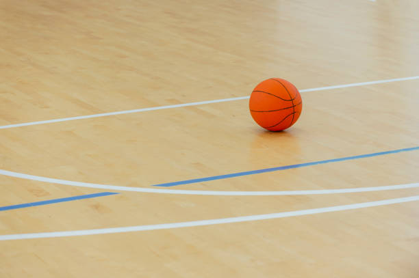 Basketball ball over floor in the gym. Team sport. Basketball ball over floor in the gym. Team sport. college basketball court stock pictures, royalty-free photos & images