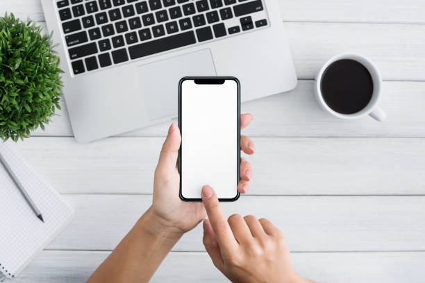 istock Hand using smartphone on white wooden background 1087264560
