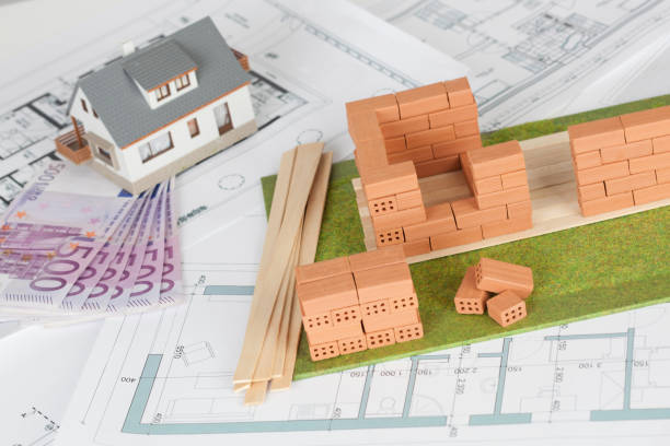 istock Model house construction with brick on blueprint and five hundred euro banknote 1087264618