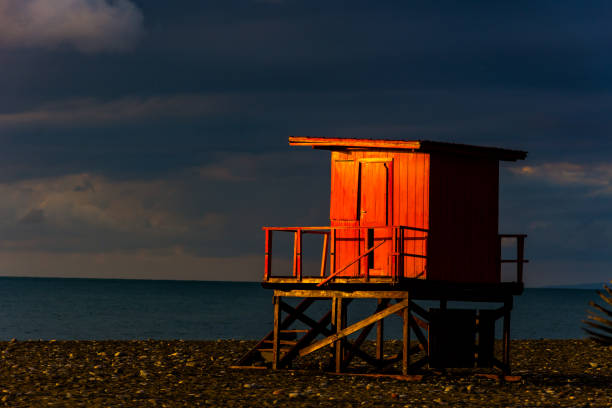 バットのビーチで小さな木の家の照明の日の出 - lifeguard orange nature beach ストックフォトと画像