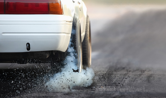 Drag racing coche quema goma de sus neumáticos en preparación para la carrera photo