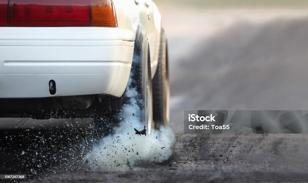Drag racing car burns rubber off its tires in preparation for the race Car Stock Photo