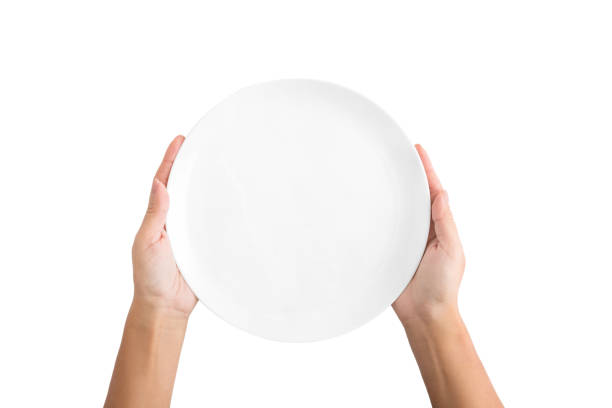 Woman holding empty plate isolated on white background Hunger concept. Woman holding empty plate waiting for food, isolated on white background, top view, copy space photos of anorexia pictures stock pictures, royalty-free photos & images