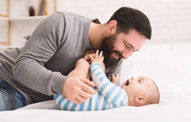 father tickling and snuggling his baby son - tickling imagens e fotografias de stock