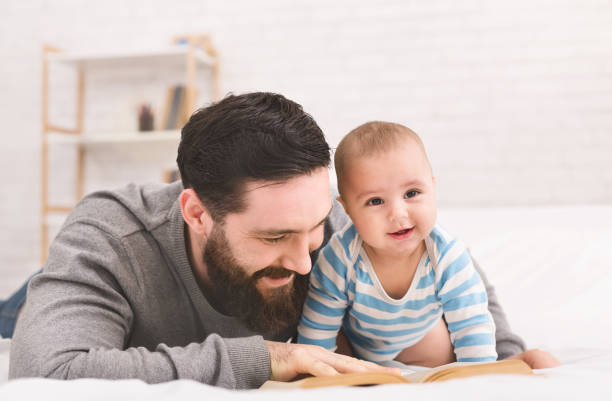 istock Father reading book to little baby son 1087272790