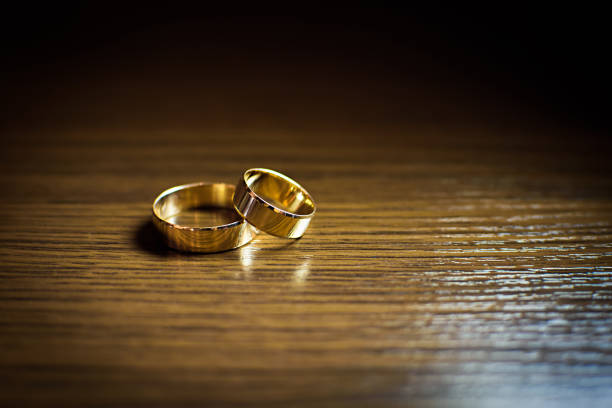 istock Gold wedding rings on a wooden table 1087278110