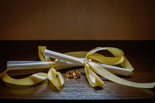 istock Gold wedding rings and paper scrolls on a wooden table 1087281344