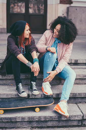 Young women sitting at the stairs and talking
