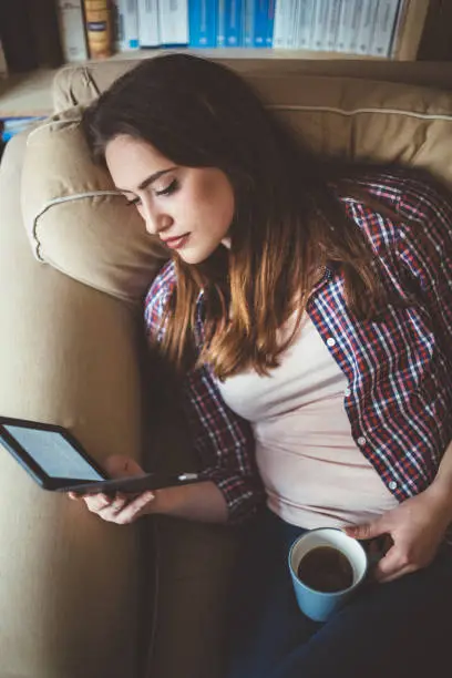 Photo of Girl in sofa reading a e-book