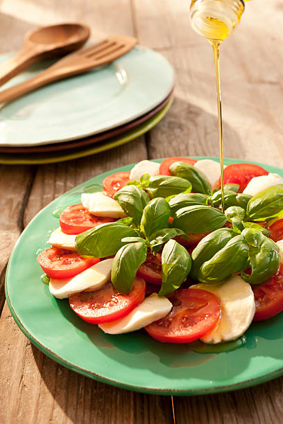 Caprese salad / Tomatoes, mozzarella, basil and olive oil stock photo