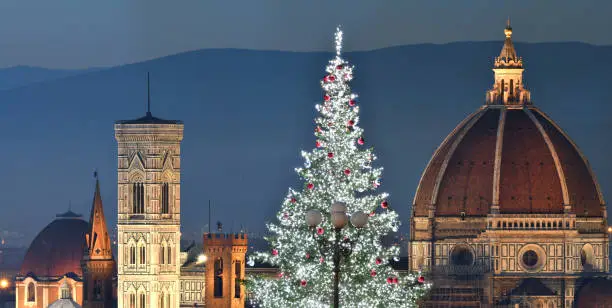 Photo of Illuminated Christmas Tree at Piazzale Michelangelo with the Cathedral of Santa Maria del Fiore on background. Italy