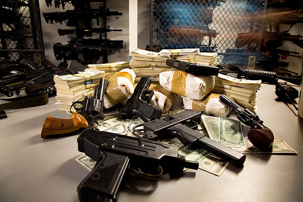 Stack of Guns, Drugs, and Cash This is a stack of guns, drugs, and cash inside a police armory.  The bundles are one kilo each and there is a Glock, a revolver, an Uzi, and a Mac-10.  For more great crime shots, check out my portfolio. military building photos stock pictures, royalty-free photos & images