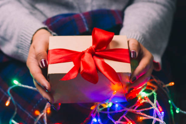 istock present box with red satin ribbon in woman hands 1087303688