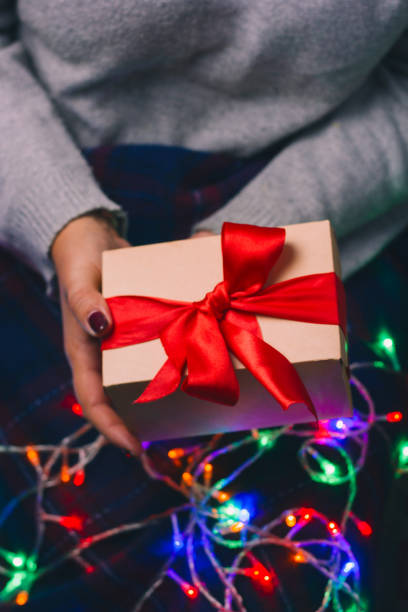 istock present box with red satin ribbon in woman hands 1087303794